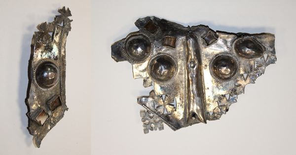 Photos of two pieces of a large elaborately decorated silver cross. 